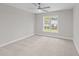 Carpeted bedroom with natural light, a ceiling fan, and gray walls at 408 W Stallings St, Clayton, NC 27520