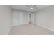 Neutral bedroom with carpeting, ceiling fan, closet, and an open doorway at 408 W Stallings St, Clayton, NC 27520
