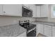 Close-up of the kitchen with granite countertops and modern stainless steel appliances at 408 W Stallings St, Clayton, NC 27520