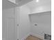 Clean, white laundry room with shelving, utility connections, and vinyl flooring at 408 W Stallings St, Clayton, NC 27520
