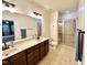 Bathroom featuring double sink vanity, a large mirror, and a glass-enclosed shower at 4405 Brighton Ridge Dr, Apex, NC 27539