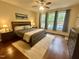Cozy bedroom features a ceiling fan, windows with a backyard pool view, and a comfortable bed at 4405 Brighton Ridge Dr, Apex, NC 27539