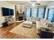 A spacious living room featuring a stone fireplace, large windows, and a comfortable sectional sofa at 4405 Brighton Ridge Dr, Apex, NC 27539