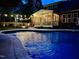 Night view of the backyard pool with string lights and screened in porch at 4405 Brighton Ridge Dr, Apex, NC 27539