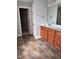 Bathroom with ceramic tile floor, wood cabinets, and a large mirror at 4509 Joe Cotton Dr, Knightdale, NC 27545