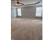Spacious bedroom with neutral carpeting, a tray ceiling, a ceiling fan, and dual windows at 4509 Joe Cotton Dr, Knightdale, NC 27545