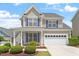 Charming two-story home with blue shutters, manicured landscaping, and an attached two-car garage at 4509 Joe Cotton Dr, Knightdale, NC 27545