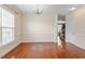 Light filled living room has hardwood floors, white trim, and a view to the staircase at 4509 Joe Cotton Dr, Knightdale, NC 27545