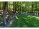 Lush green backyard with mature trees, landscaped rocks and plants, and a small bird bath at 5025 Martin Farm Rd, Raleigh, NC 27613