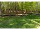 Spacious backyard with mature trees, lush grass, and rock landscaping at 5025 Martin Farm Rd, Raleigh, NC 27613