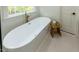 Elegant bathroom with freestanding tub, gold faucet, and a view of the outdoors at 5025 Martin Farm Rd, Raleigh, NC 27613
