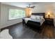 Spacious bedroom with a large window, ceiling fan, and dark wood-look flooring at 5025 Martin Farm Rd, Raleigh, NC 27613