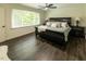Comfortable bedroom with a ceiling fan, hardwood floors, and large windows that offer plenty of natural light at 5025 Martin Farm Rd, Raleigh, NC 27613