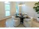 Well-lit dining room featuring a modern chandelier, table setting, and large windows at 5025 Martin Farm Rd, Raleigh, NC 27613