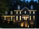 Stately brick home with manicured landscaping and illuminated facade at 5025 Martin Farm Rd, Raleigh, NC 27613