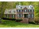 Traditional brick home with well-manicured lawn, dormer windows, and lush surrounding greenery at 5025 Martin Farm Rd, Raleigh, NC 27613