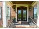 Inviting brick home entrance featuring an ornate, dark wood front door and decorative ironwork at 5025 Martin Farm Rd, Raleigh, NC 27613