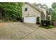 A lovely exterior angle of a two car garage, attached to the home, with a driveway and surrounding greenery at 5025 Martin Farm Rd, Raleigh, NC 27613