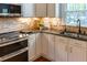Close-up of a kitchen showcasing granite countertops, a stone backsplash, and modern appliances at 5025 Martin Farm Rd, Raleigh, NC 27613