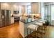 Well-lit kitchen featuring a large island, modern stainless steel appliances, and warm wood floors at 5025 Martin Farm Rd, Raleigh, NC 27613