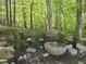 Landscaping featuring a stone fountain surrounded by rocks, mulch, and various plants at 5025 Martin Farm Rd, Raleigh, NC 27613