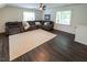 Open-concept living room with hardwood floors, a large sectional sofa, and plenty of natural light at 5025 Martin Farm Rd, Raleigh, NC 27613