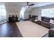 Spacious living room with dark laminate flooring, comfortable seating, and natural light from multiple windows at 5025 Martin Farm Rd, Raleigh, NC 27613