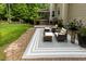 Paver patio features an outdoor rug and cushioned seating with an adjacent grassy area at 5025 Martin Farm Rd, Raleigh, NC 27613