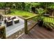 Paver patio and wood deck offers cushioned seating and a tranquil view of landscaped yard at 5025 Martin Farm Rd, Raleigh, NC 27613