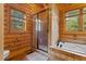Bathroom featuring a glass enclosed shower, soaking tub, and wood accents at 6707 Frieden Church Rd, Gibsonville, NC 27249
