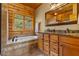 Elegant bathroom featuring a soaking tub, wood cabinets and double sink vanity at 6707 Frieden Church Rd, Gibsonville, NC 27249