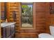 Wood bathroom with a single sink vanity, toilet, window, and towel rack at 6707 Frieden Church Rd, Gibsonville, NC 27249