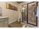 Bathroom featuring tiled shower with glass enclosure, neutral walls, and decorative art at 6707 Frieden Church Rd, Gibsonville, NC 27249