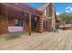 Spacious wooden deck with a porch swing, red doors, stone accents, and an inviting outdoor seating area at 6707 Frieden Church Rd, Gibsonville, NC 27249