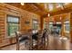 Cozy dining room with wood walls, large windows and ample seating for eight guests at 6707 Frieden Church Rd, Gibsonville, NC 27249