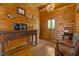 Cozy living room with wood walls, floors, and furniture, a wooden door, and cabin decor at 6707 Frieden Church Rd, Gibsonville, NC 27249
