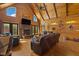 Cozy living room featuring vaulted ceilings, a stone fireplace, hardwood floors, and comfortable leather seating at 6707 Frieden Church Rd, Gibsonville, NC 27249