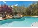 Outdoor swimming pool with integrated hot tub surrounded by natural rock formations and greenery at 6707 Frieden Church Rd, Gibsonville, NC 27249