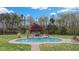 Stunning pool with rock features and landscaping, surrounded by lush greenery and blue sky backdrop at 6707 Frieden Church Rd, Gibsonville, NC 27249