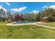 Beautiful pool area with rock features, a thatched-roof hut, and a lush green lawn at 6707 Frieden Church Rd, Gibsonville, NC 27249