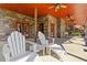 Inviting covered porch with stone columns and comfortable Adirondack seating at 6707 Frieden Church Rd, Gibsonville, NC 27249