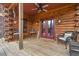 Cozy covered porch with comfortable seating and rustic log cabin details at 6707 Frieden Church Rd, Gibsonville, NC 27249