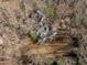 Aerial view of a home surrounded by trees showcasing the backyard with a hot tub and covered patio at 7116 Asheway Dr, Holly Springs, NC 27540