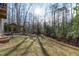 Expansive backyard with mature trees, a pergola-covered hot tub, and a fire pit area at 7116 Asheway Dr, Holly Springs, NC 27540