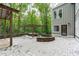A backyard with a hot tub, gazebo and a stone patio, next to a home with gray siding at 7116 Asheway Dr, Holly Springs, NC 27540