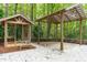 Backyard featuring a gazebo and covered patio, a stone patio, and green trees in the background at 7116 Asheway Dr, Holly Springs, NC 27540