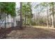 Backyard showing yard, trees, and stairs to a deck above at 7116 Asheway Dr, Holly Springs, NC 27540