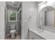 Bright bathroom featuring a glass shower, single sink, and white cabinets at 7116 Asheway Dr, Holly Springs, NC 27540