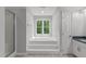 Light and airy bathroom features a soaking tub, shower, and large window at 7116 Asheway Dr, Holly Springs, NC 27540