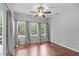 The room is bright with natural light from large windows, has a fan, and has wood floor at 7116 Asheway Dr, Holly Springs, NC 27540
